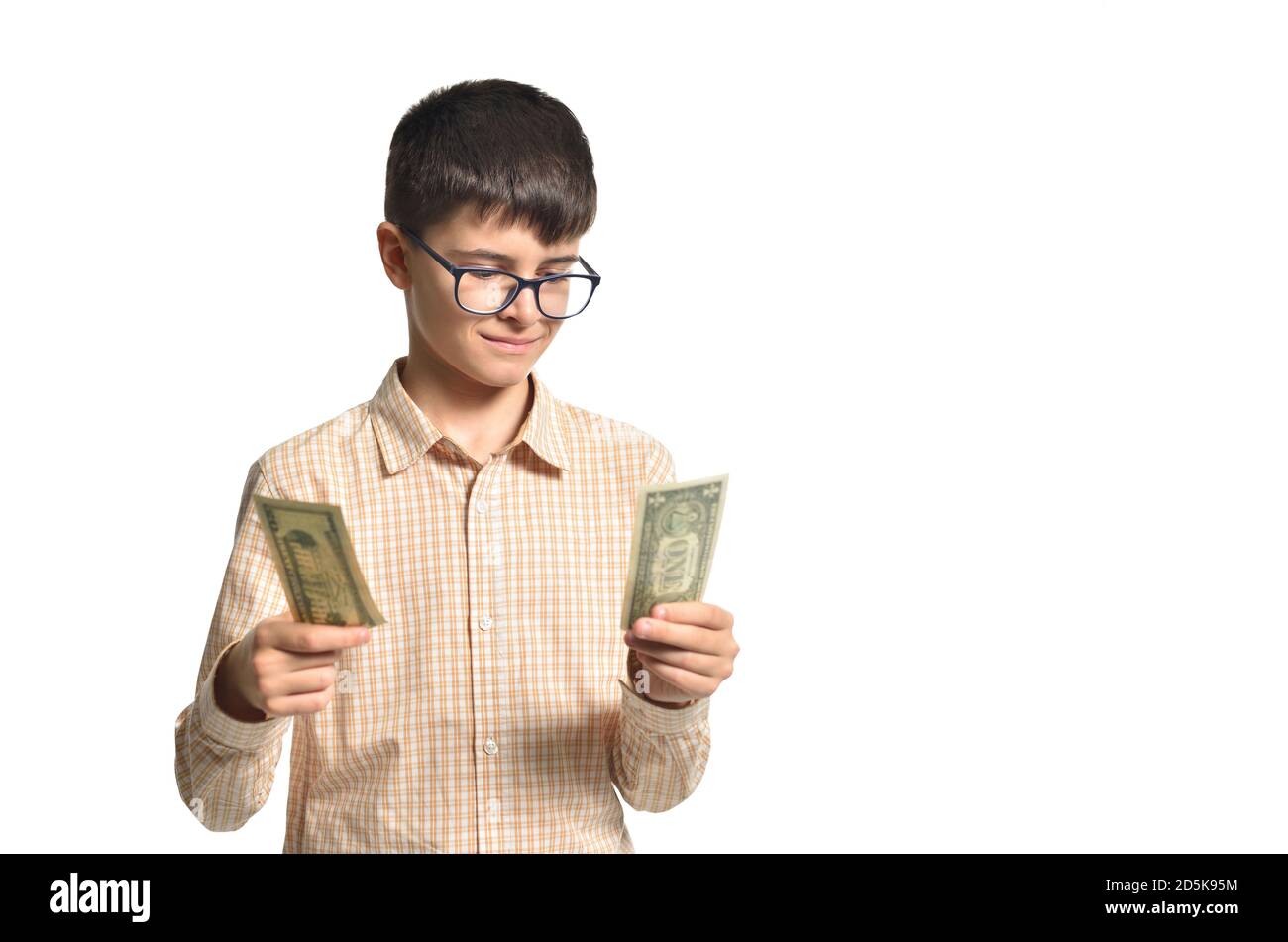 Boy teenager holding his money and considering it on white isolated background Stock Photo