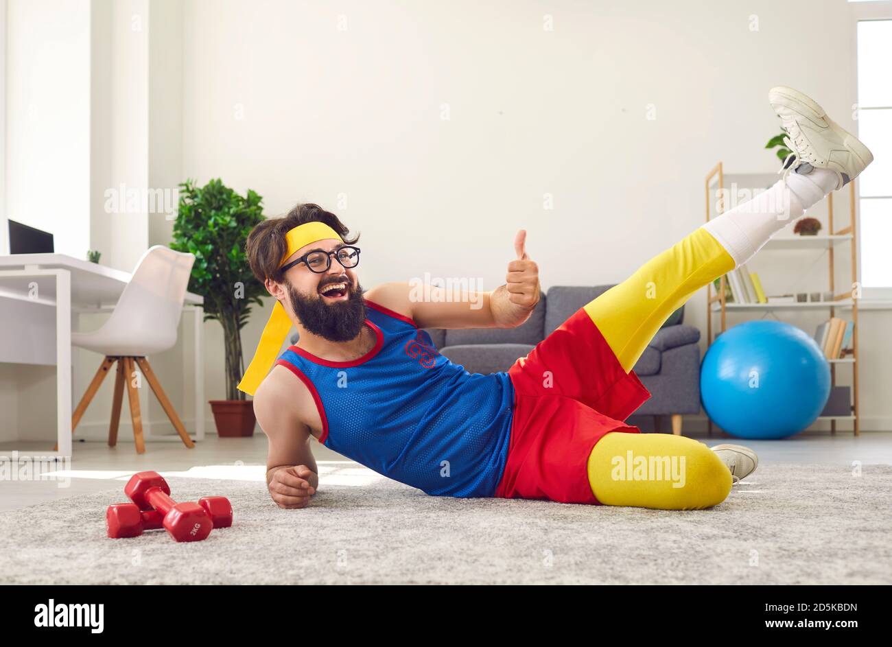 Cheerful bearded man in colorful sportswear doing sports workout at home Stock Photo