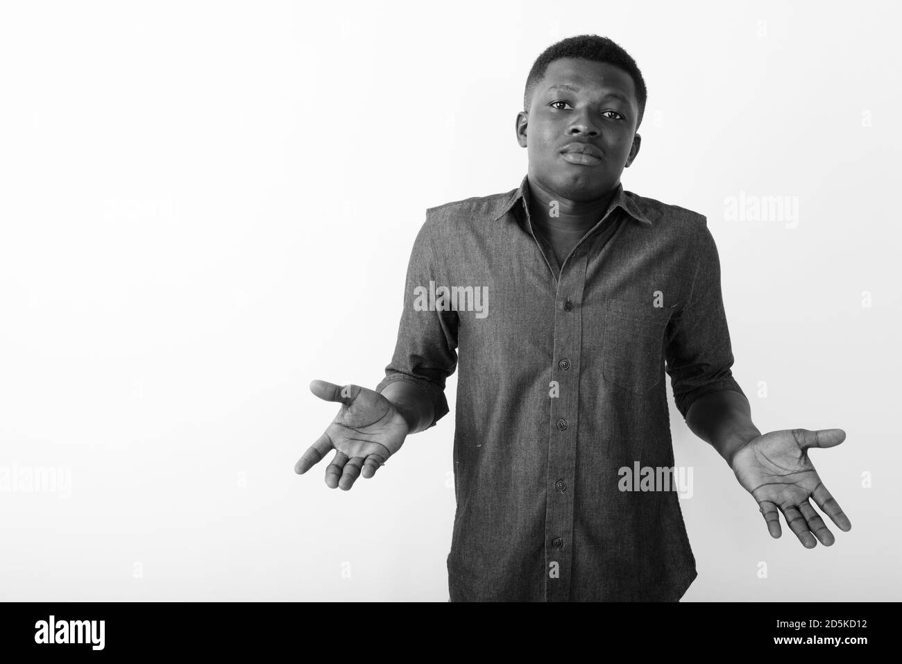 Studio shot of young black African man looking confused against white background Stock Photo