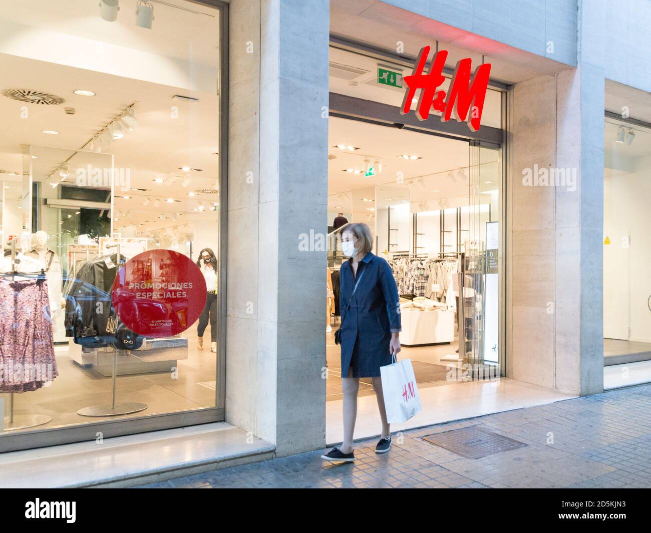 A woman wearing a face mask seen leaving the H&M store Stock Photo - Alamy