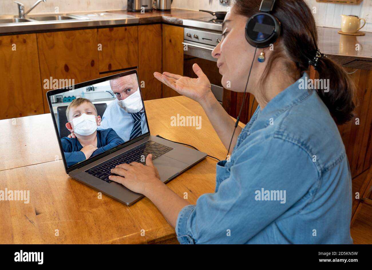 Primary Teacher video calling student young child and parent in self isolation after being tested positive for COVID-19. Reopening of Schools, online Stock Photo