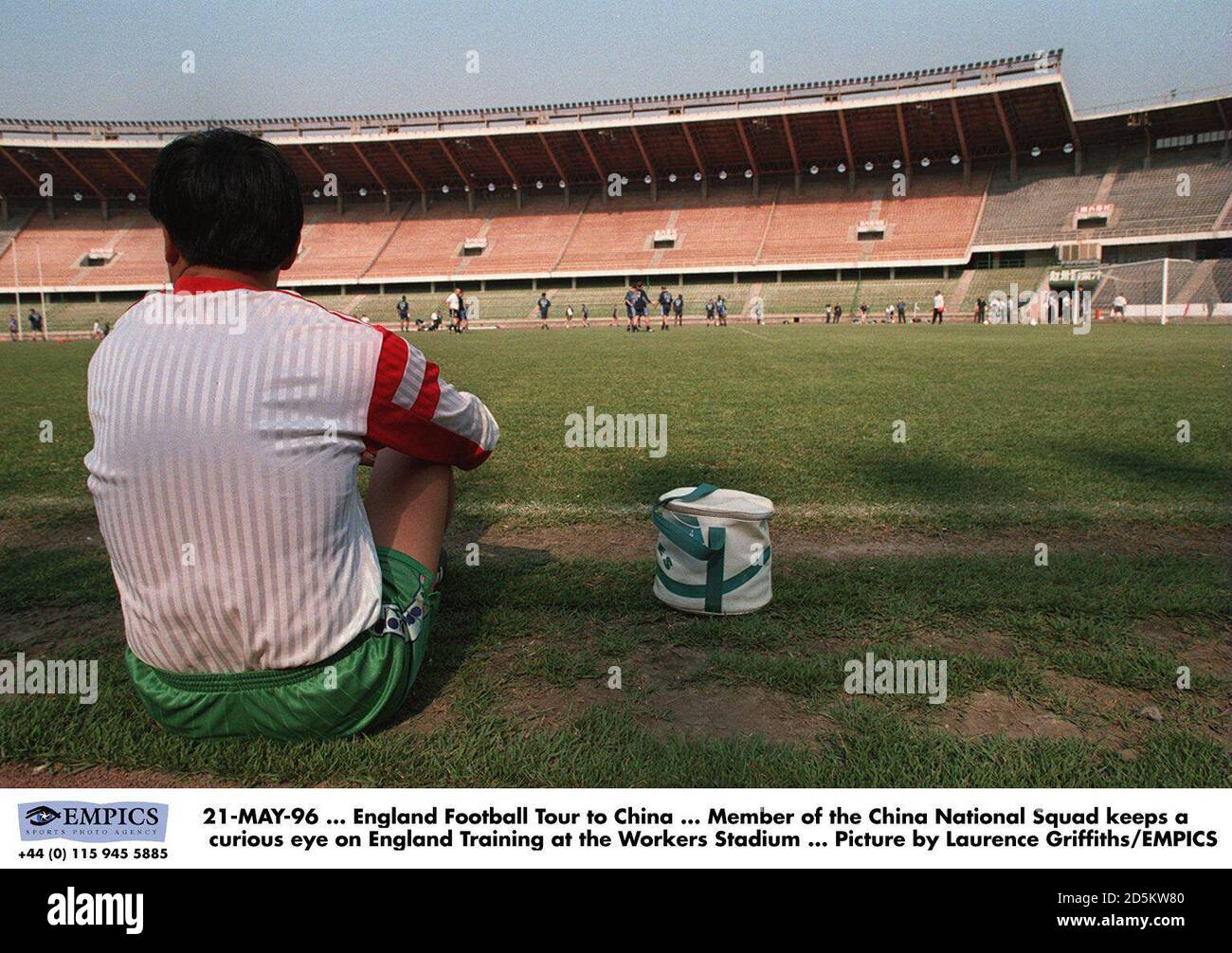 Member of the China National Squad keeps a curious eye on England Training at the Workers Stadium Stock Photo
