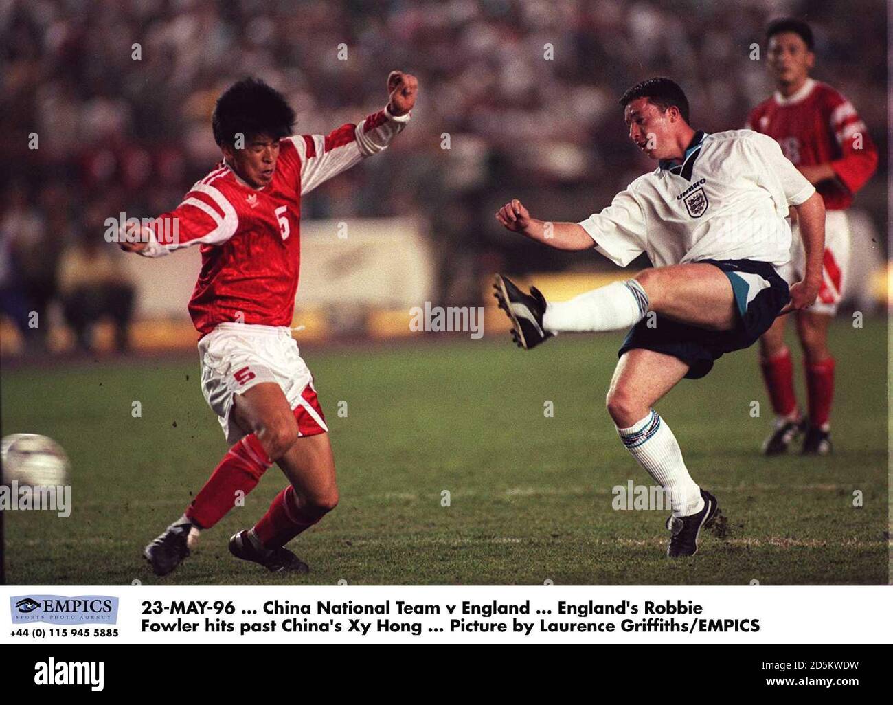 England's Robbie Fowler hits past China's Xy Hong Stock Photo