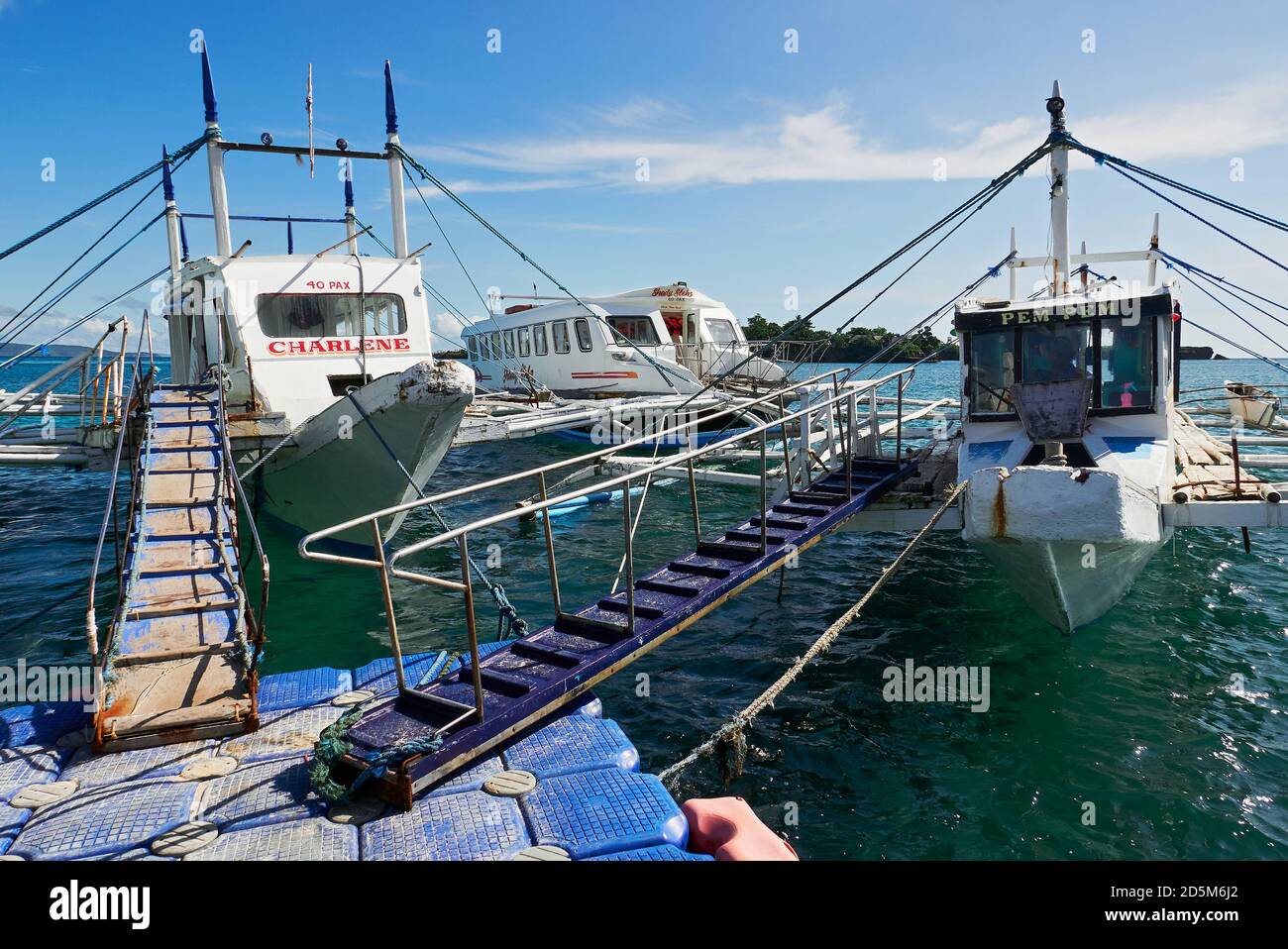 Traditional ferry boats docked to a floating plastic platform at Tabon Port in Caticlan, Aklan Province, the gateway to Boracay Island, Philippines Stock Photo