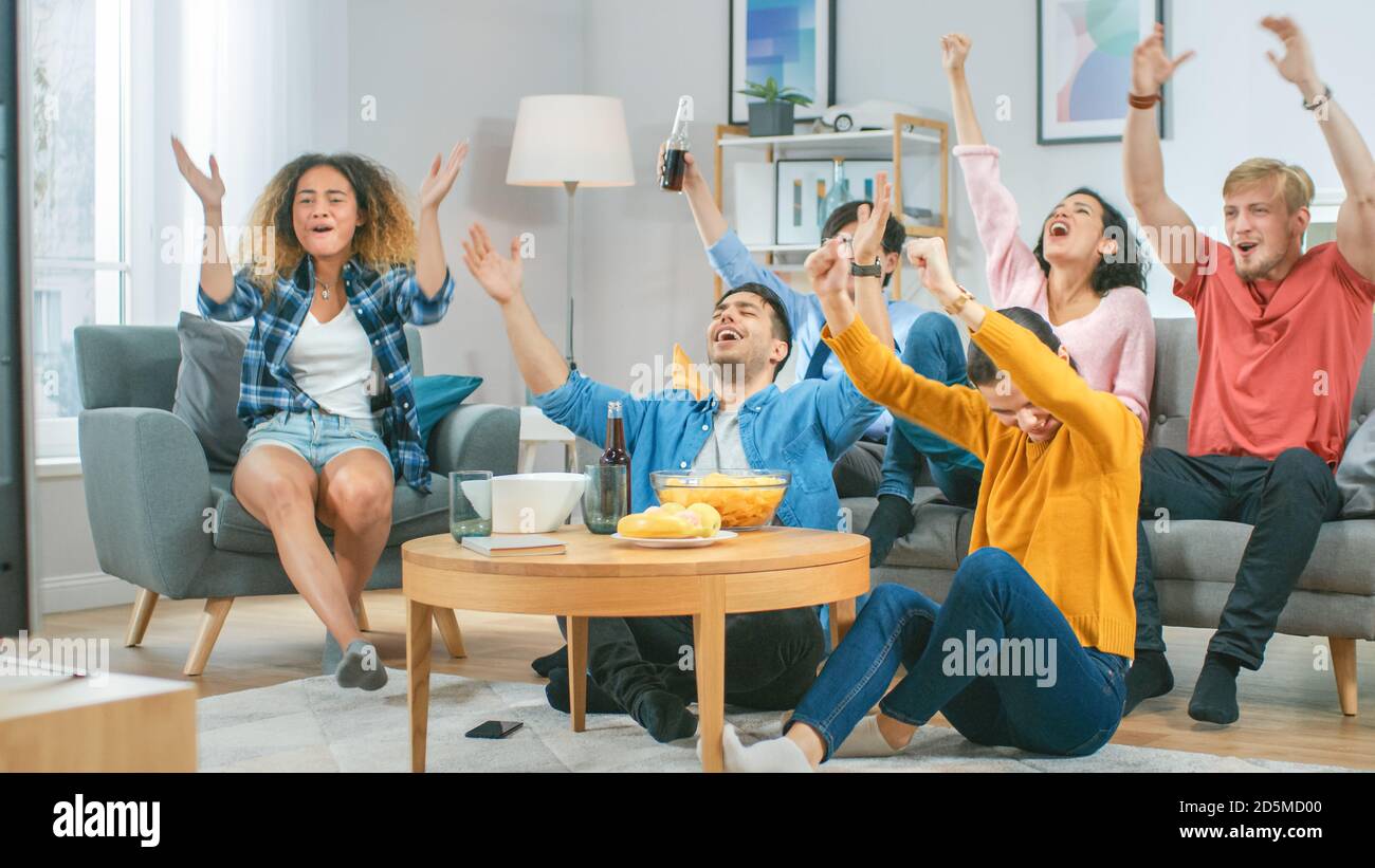 At Home Diverse Group of Sports Fans Sitting on a Couch Watching