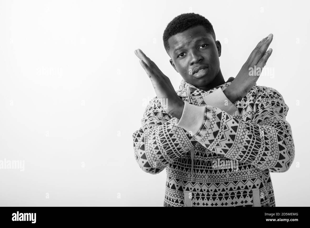 Studio shot of young black African man showing stop hand gesture with ...