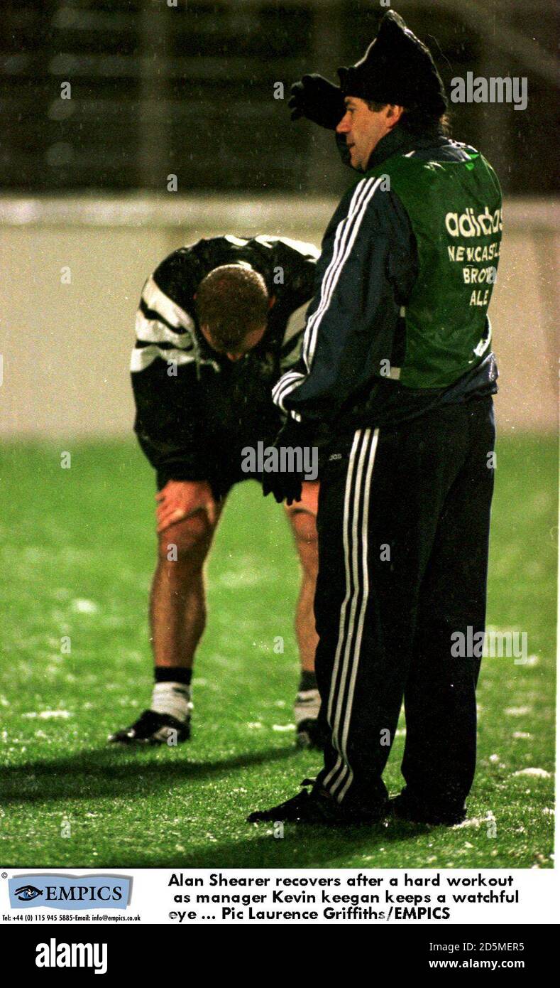 Alan Shearer recovers after a hard workout as manager Kevin Keegan keeps a watchful eye Stock Photo
