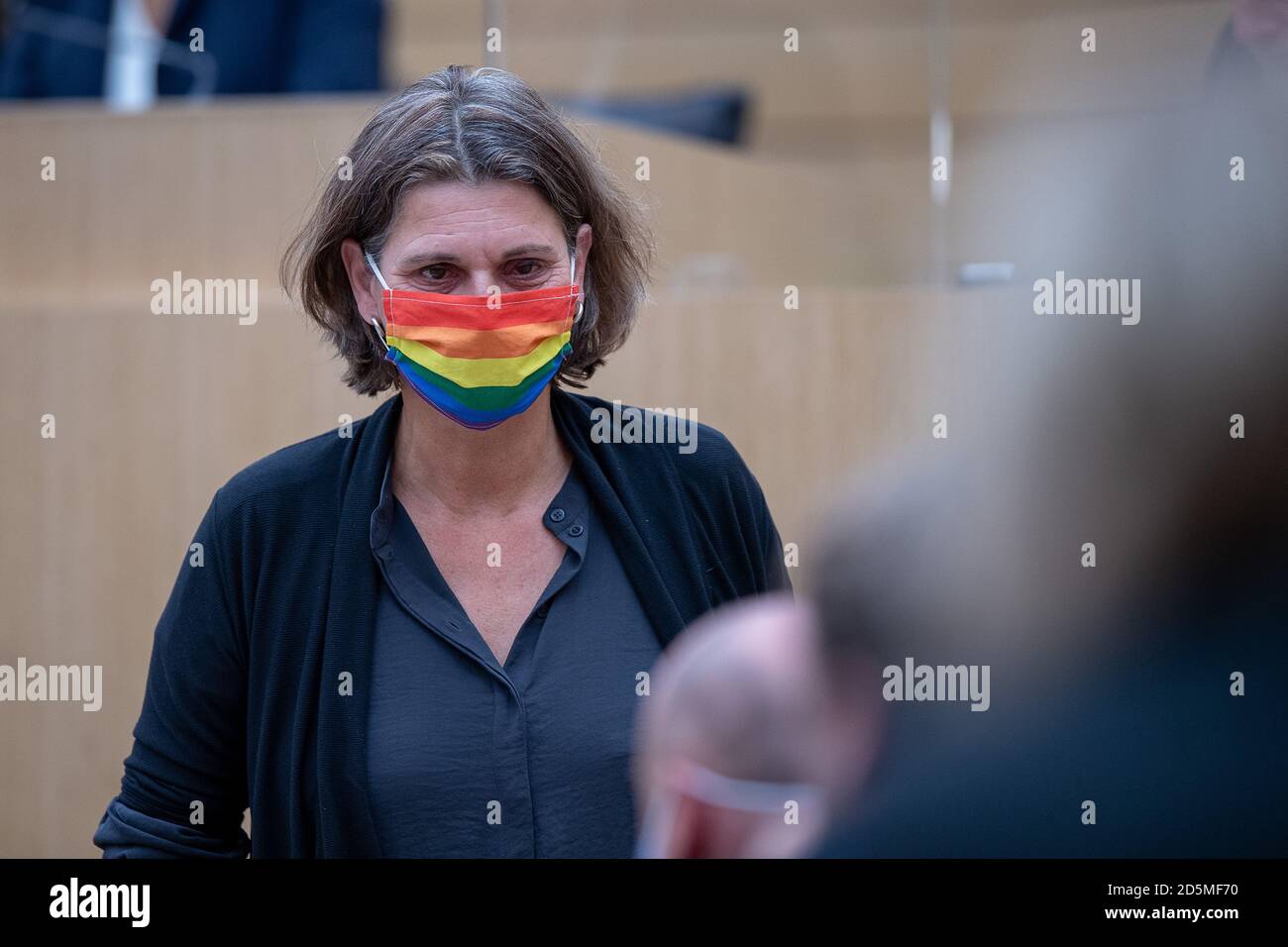 Stuttgart, Germany. 14th Oct, 2020. Brigitte Lösch (Bündnis 90/Die Grünen), member of the 16th state parliament of Baden-Württemberg, walks through the state parliament with a rainbow mask during the 128th session of the 16th state parliament of Baden-Württemberg. The topic was among others more acceptance and equal rights for LSBTTIQ (lesbians, gays, bisexuals, transgender, transsexuals, intersexuals and queer). Credit: Sebastian Gollnow/dpa/Alamy Live News Stock Photo