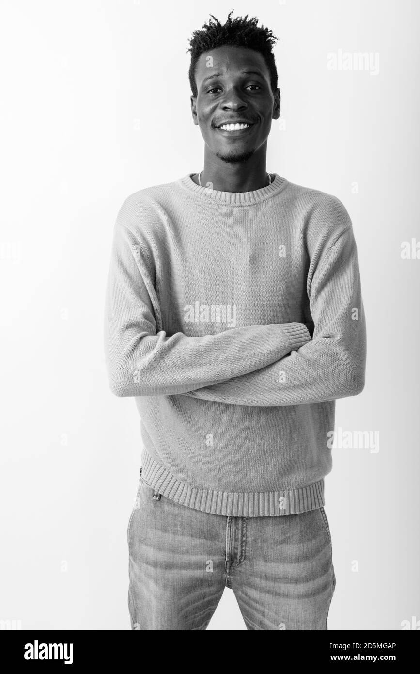Studio shot of young happy black African man smiling and standing with ...