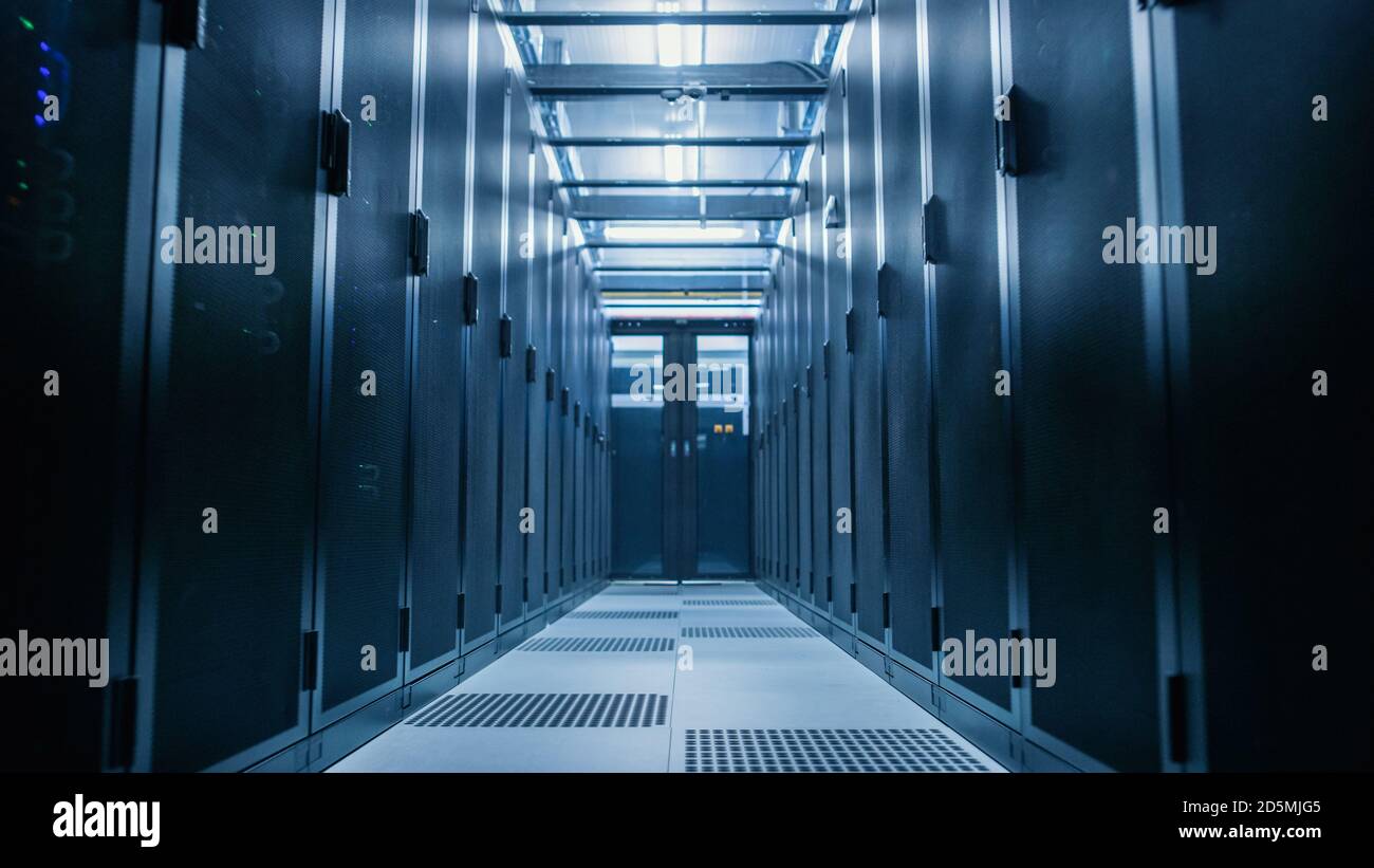 Data Center With Between Two Rows of Fully Operational Server Racks. Modern Telecommunications, Cloud Computing, Artificial Intelligence, Database Stock Photo
