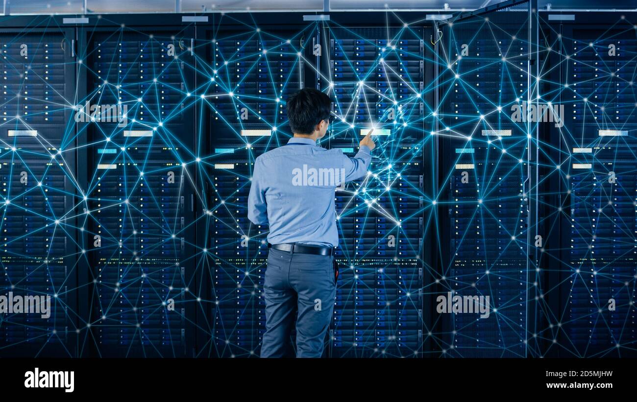 Internet Web Concept. Shot In the Modern Data Center: IT Engineer Standing Beside Open Server Rack Cabinets and Touching Digital Connections on a Stock Photo