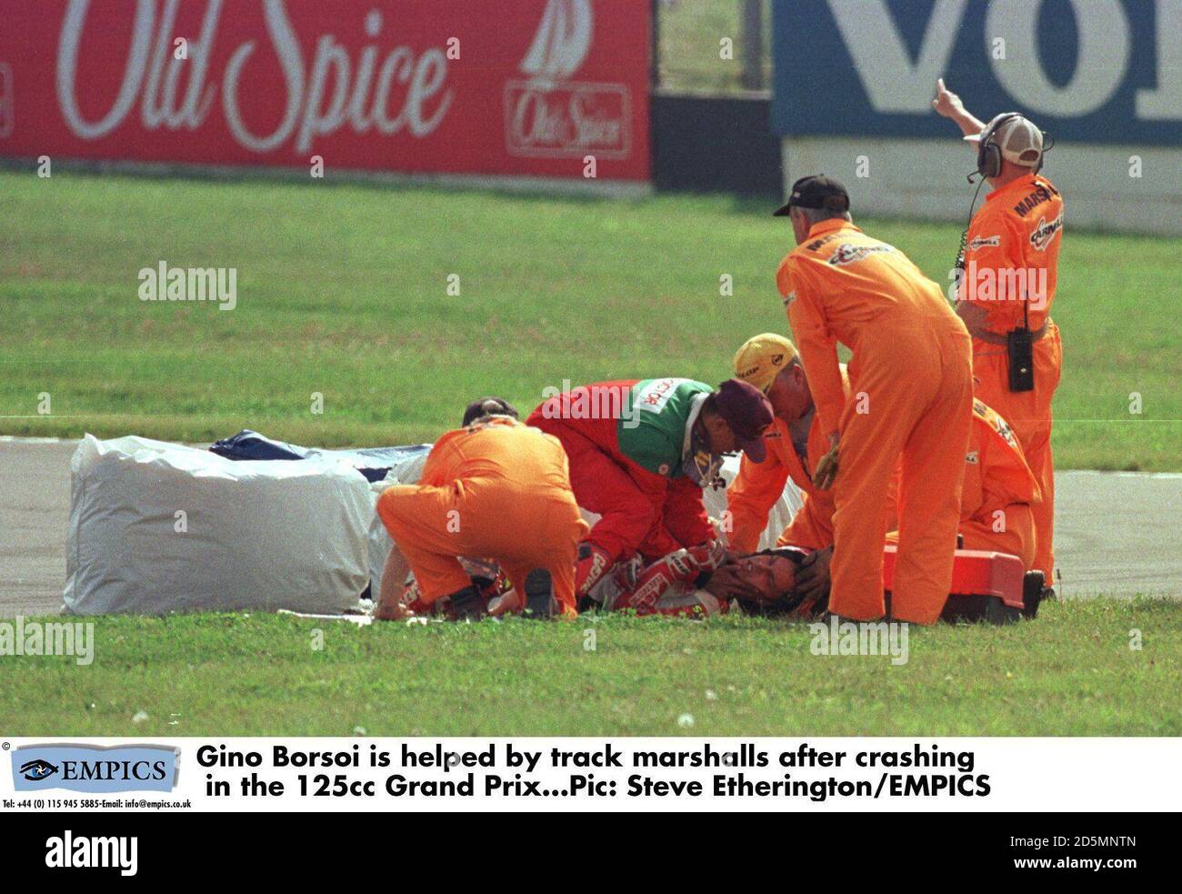 Gino Borsoi is helped by track marshalls after crashing in the 125cc Grand Prix Stock Photo