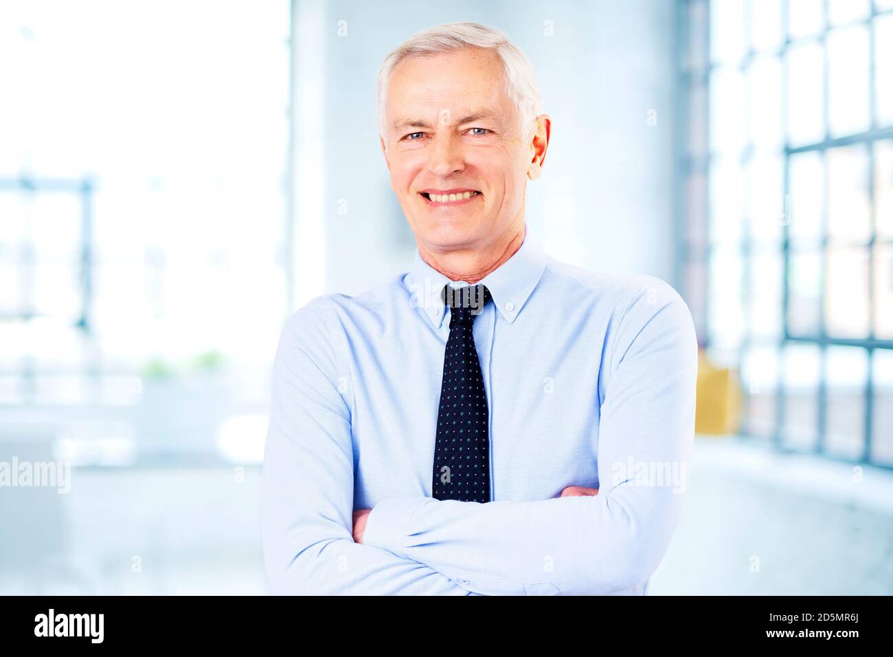 Portrait shot of smiling senior businessman wearing shirt and tie while ...