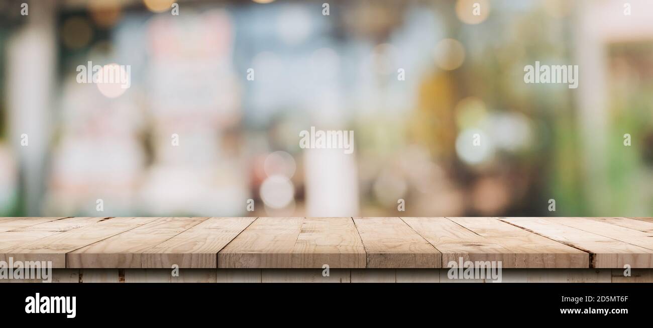 Empty wood table and blurred light table in coffee shop and cafe with ...