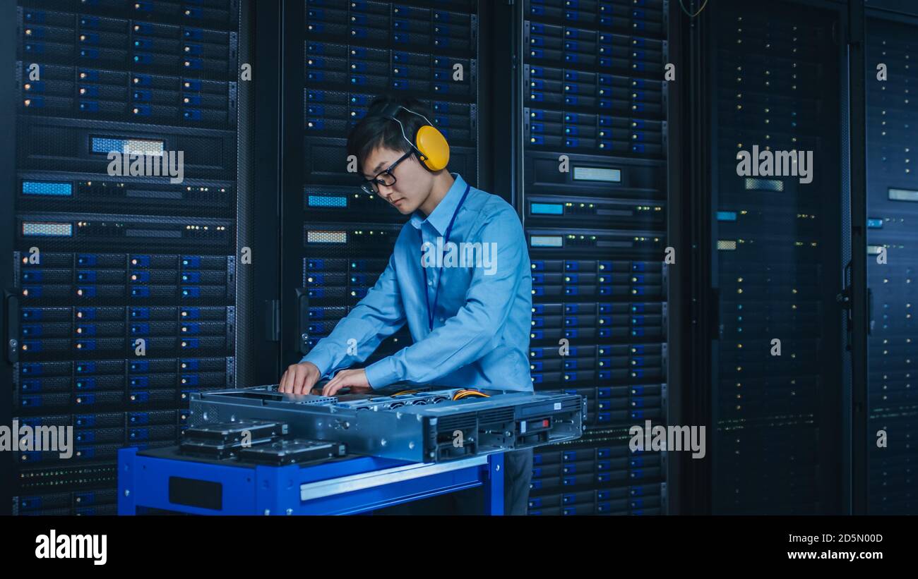 In the Modern Data Center IT Technician Wearing Protective Headphones