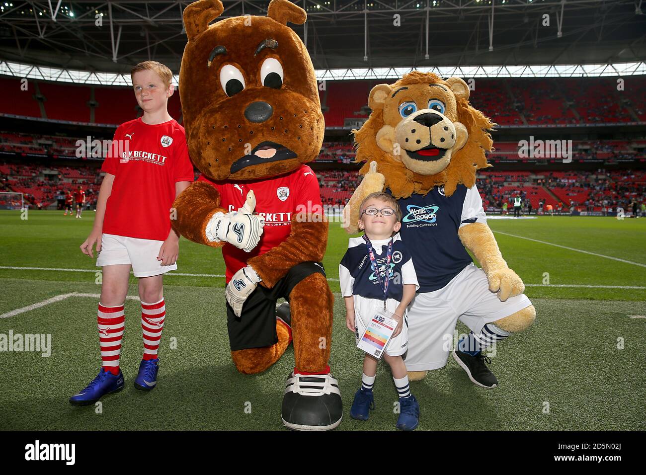 A young mascot with Barnsley Mascot Toby Tyke and Millwall mascot Zampa the Lion.  Stock Photo