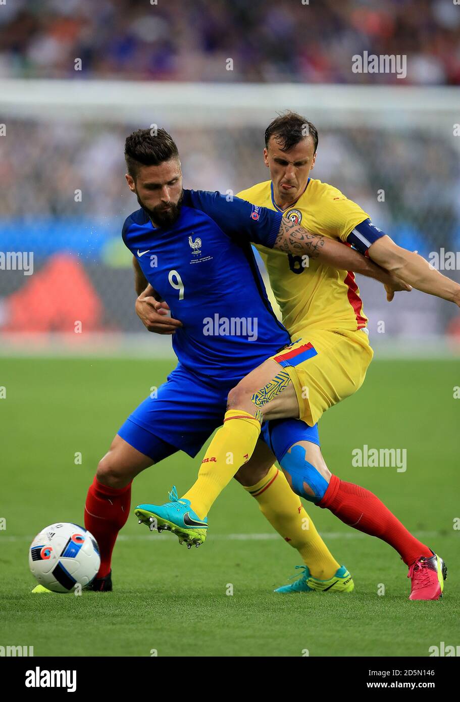 France's Olivier Giroud (left) and Romania's Vlad Chiriches battle for the ball Stock Photo