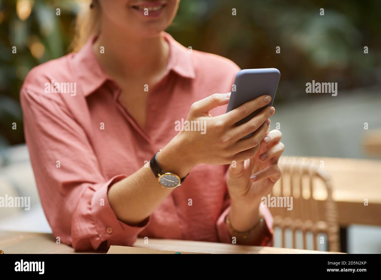 Close-up of young woman typing online message on her smartphone Stock Photo
