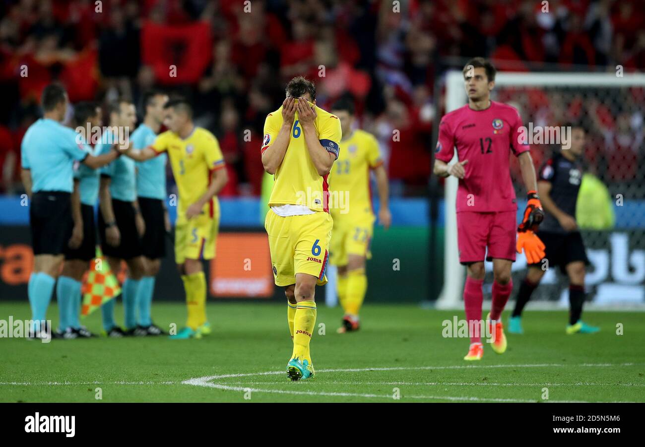 Romania's Vlad Chiriches (centre) appears dejected after the final whistle Stock Photo