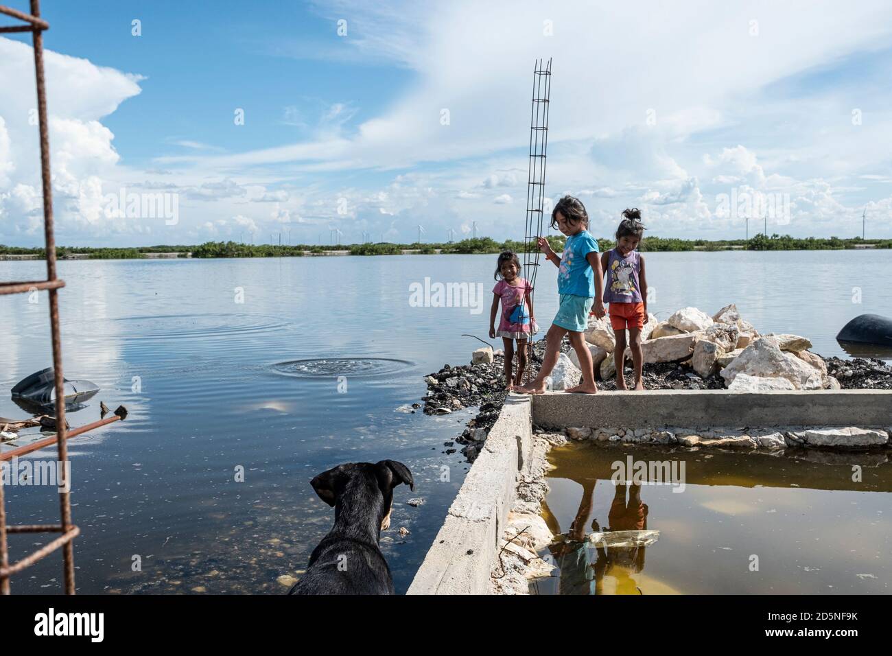 Chicxulub Puerto, Mexico. 10th Oct, 2020. Angeles (r-l), Citlati and America play on the riverbank. In the shanty town on the edge of a swamp in Chicxulub Puerto, where most houses have neither electricity nor running water, flooding is becoming increasingly common. Due to lack of resources, many children living in the community are unable to follow lessons on television or the Internet during the Corona pandemic. Credit: Jacky Muniello/dpa/Alamy Live News Stock Photo