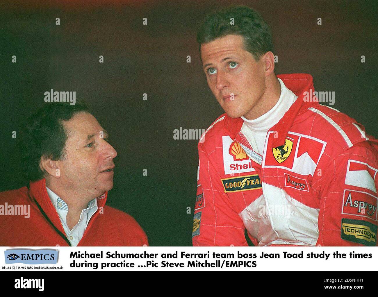 Michael Schumacher (right) and Ferrari team boss Jean Todt (left) study the  times during practice Stock Photo - Alamy