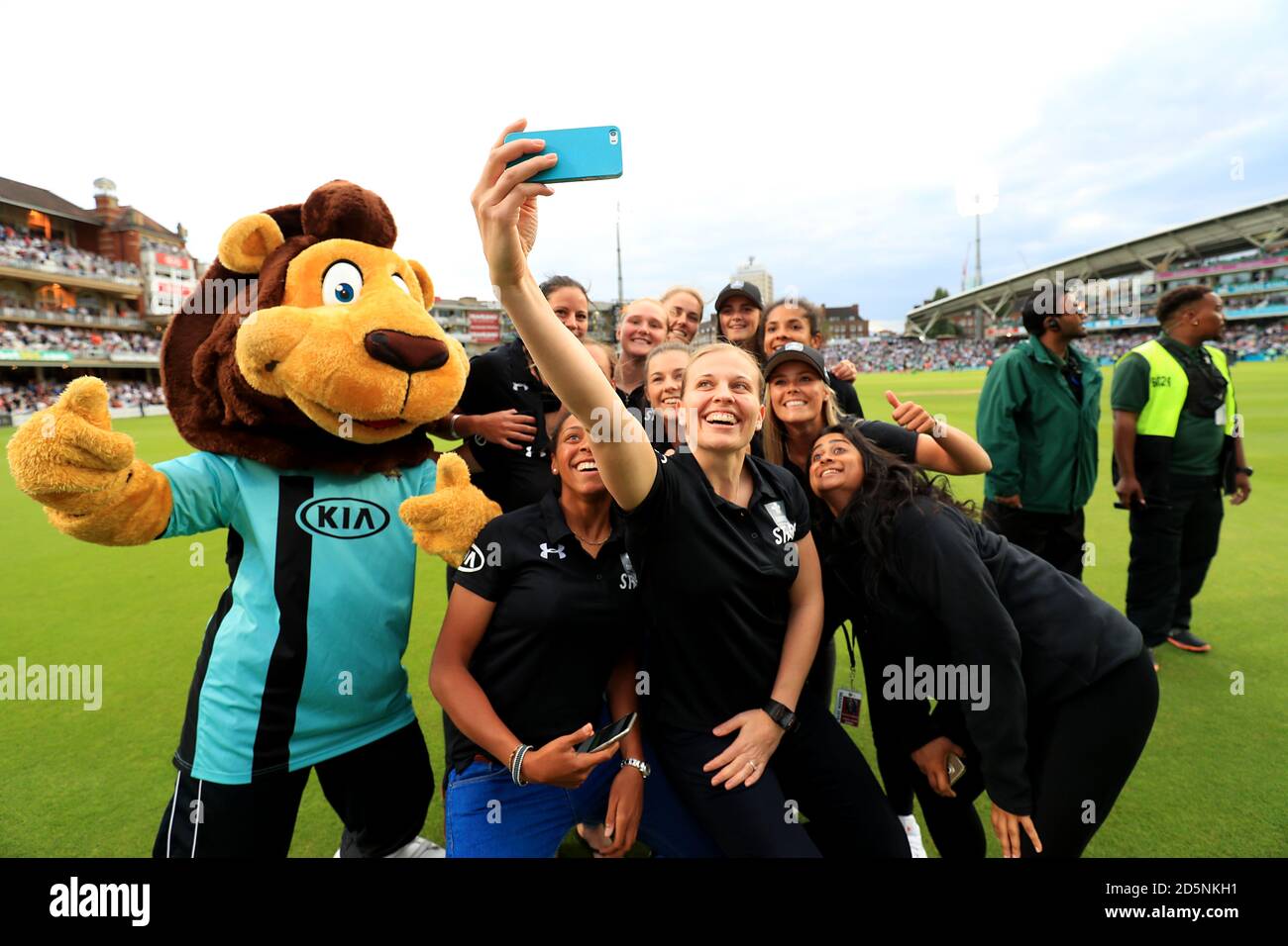 Promotional girls take a selfie on the pitch with Surrey mascot Caesar the Lion  Stock Photo