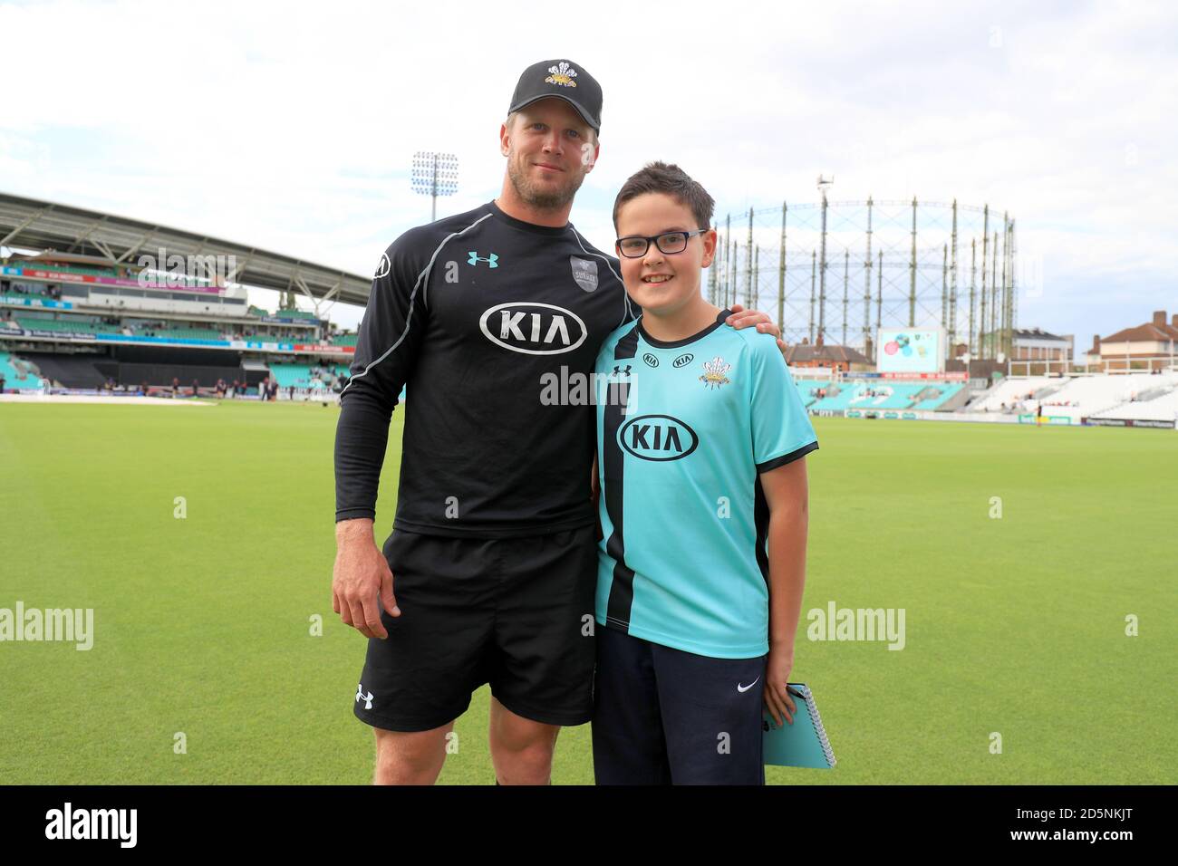 Surrey's Stuart Meaker poses with a young mascot prior to the match.  Stock Photo