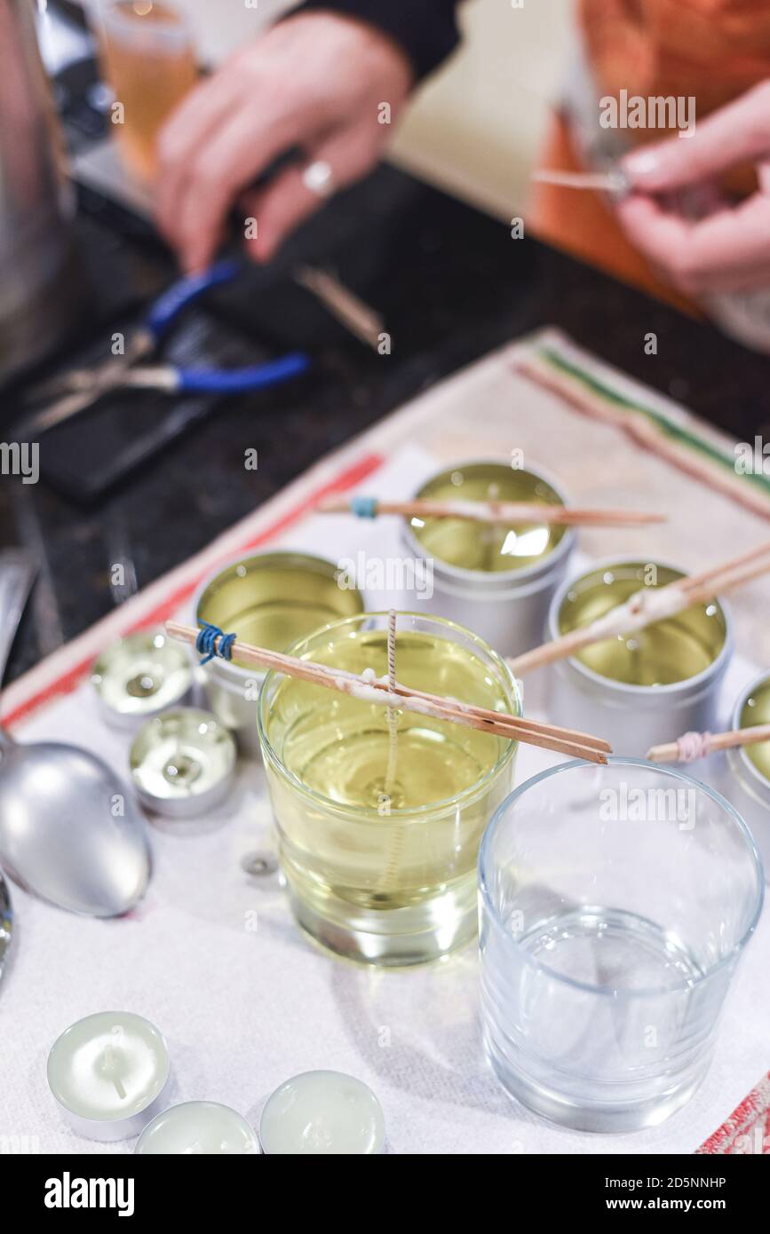 Making candles at home and adding a wick to liquid candle wax Stock ...