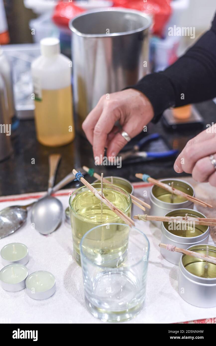 Making candles at home and adding a wick to liquid candle wax Stock