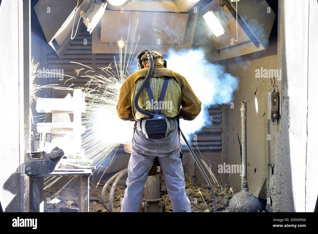 Welder in protective clothing at the workplace in an industrial company