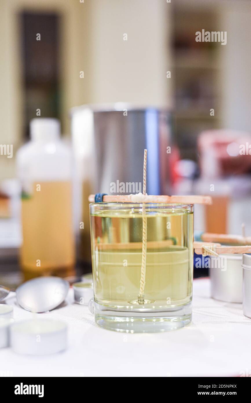 Making candles at home and adding a wick to liquid candle wax Stock