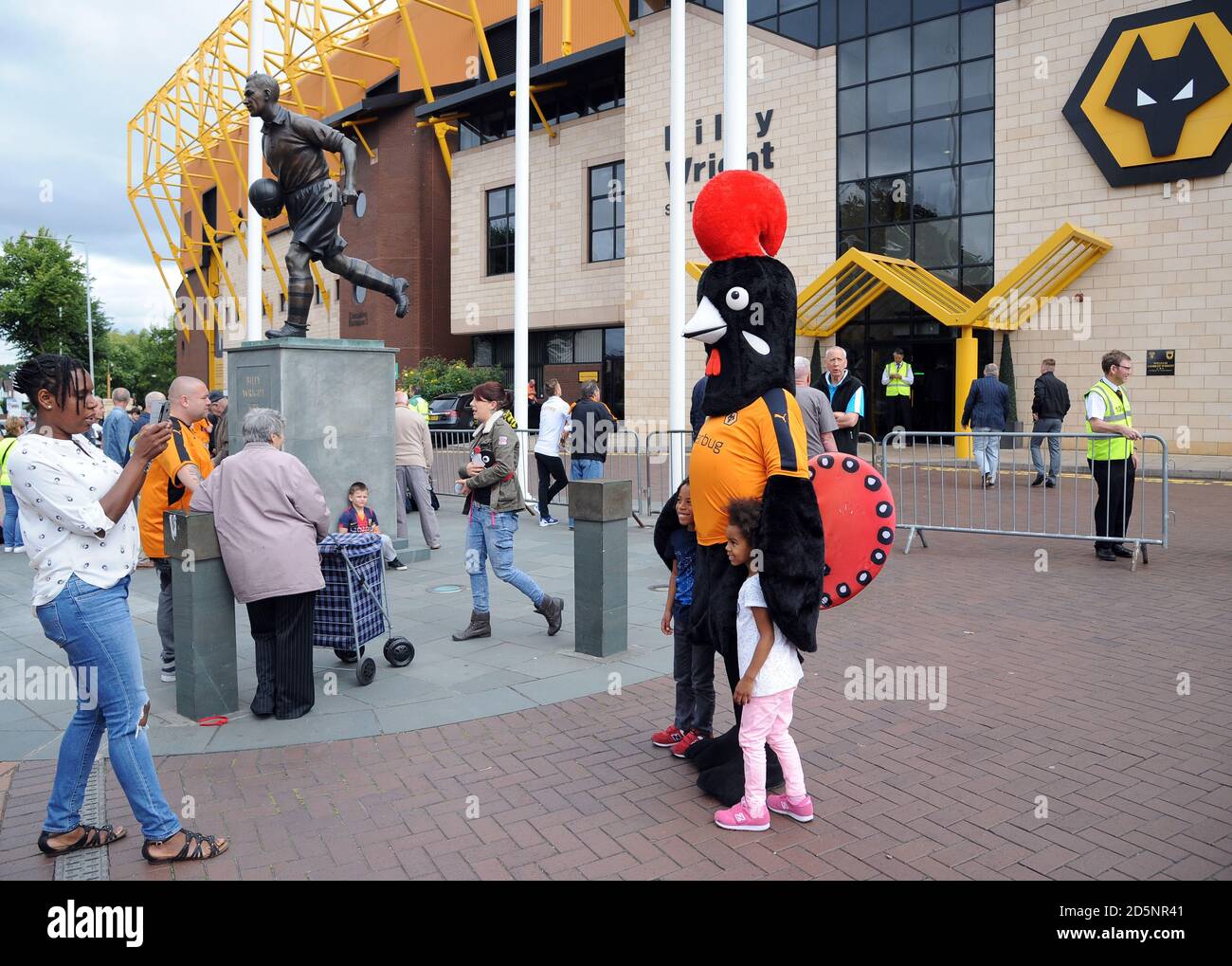 Fans pose for photos with Wolverhampton club mascot outside Molineux stadium before the Wolverhampton Wanderers and Reading match at the Molineux Stadium. Stock Photo