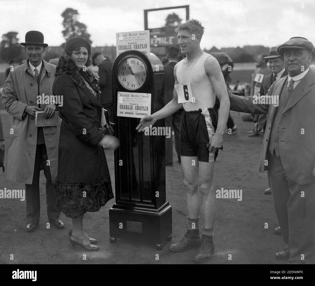 A grandfather clock donated by Charlie Chaplin, the famous film star, was the first prize in the one-mile race at Herne Hill. Mrs Richardson presents the clock to J. Reynolds, winner of the race. Stock Photo