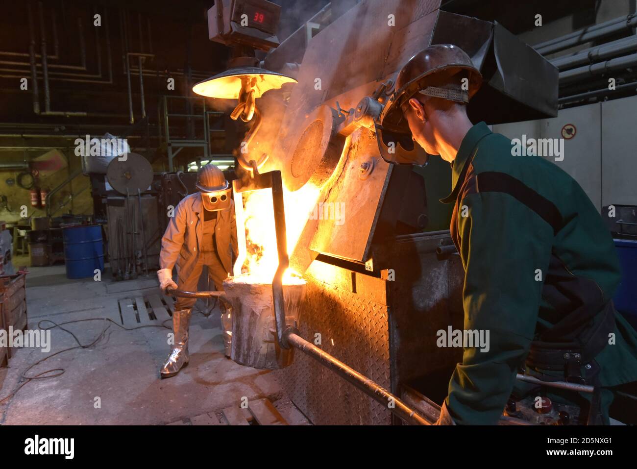 workers in a foundry casting a metal workpiece safety at work and