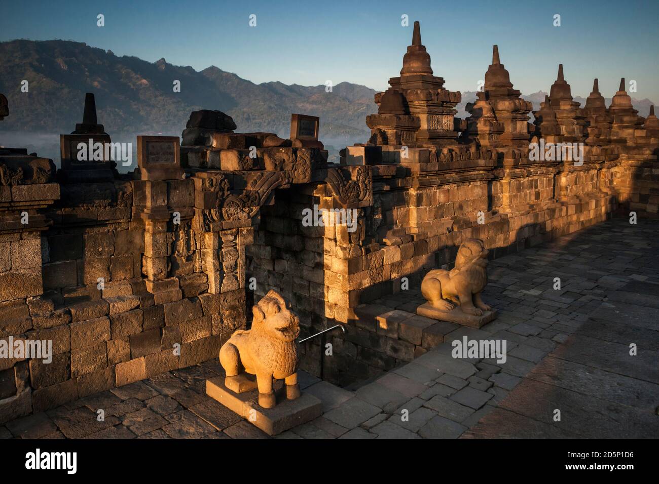 Horizontal view of a Borobudur Buddhist Temple upper terrace with stone guardians at sunrise, Borobudur, Java, Indonesia Stock Photo