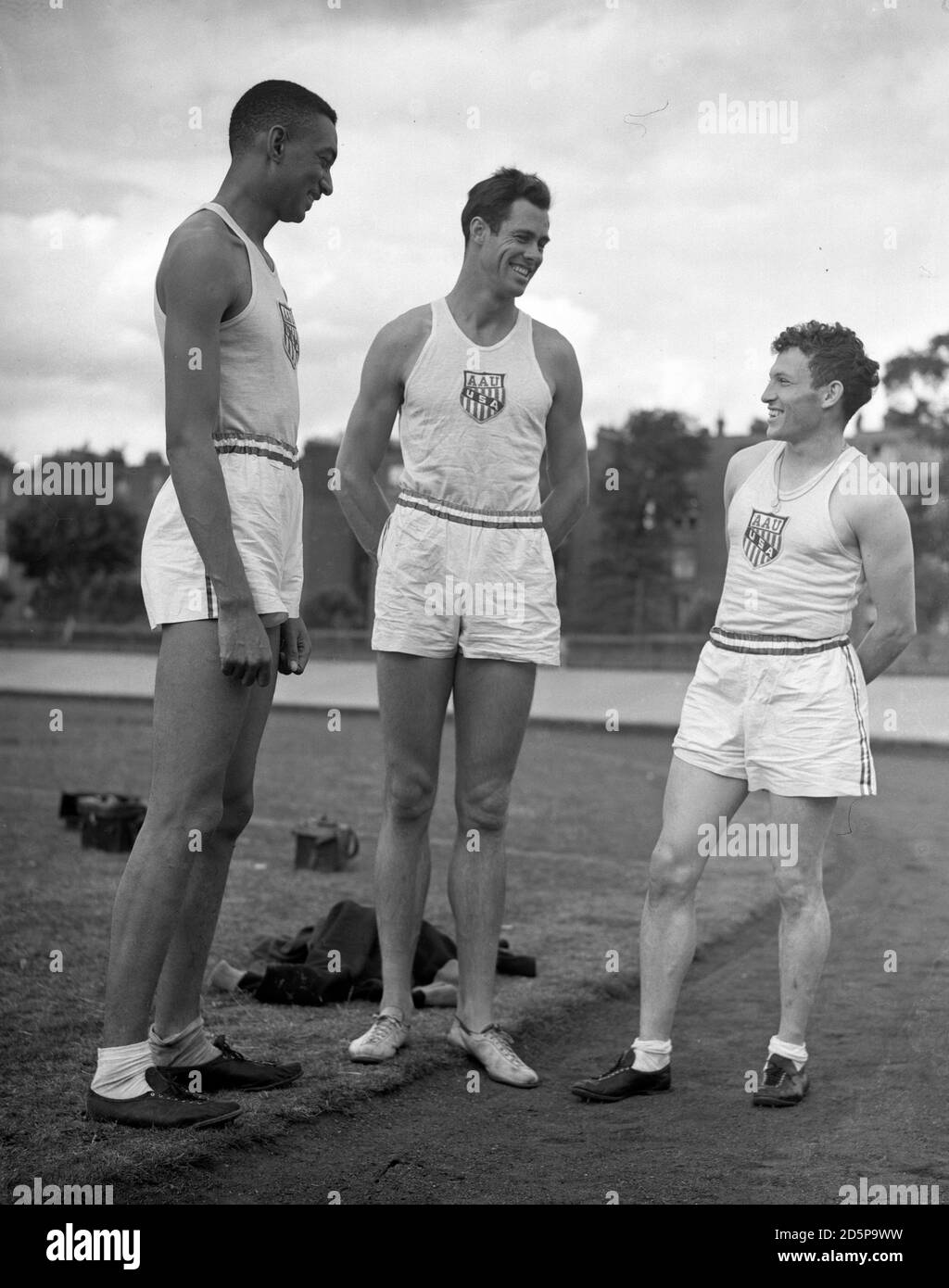 The tallest members of the American team - Melvin Walker, the high jumper, is 6 feet 4 inches, and Perrin Walker, sprinter, who is 6 feet 5 inches, with Greg Rice, 5,000 metres competitor, who is only 5 feet 4 inches. Stock Photo