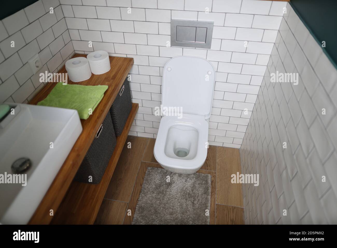 Bathroom with toilet bowl washbasin towel and toilet paper Stock Photo