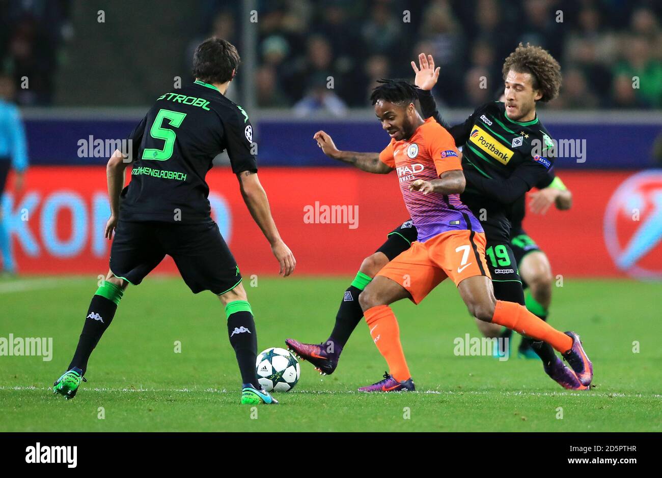 Borussia Monchengladbach's Tobias Strobl (left) and Fabian Johnson (right) battle for the ball with Manchester City's Raheem Sterling (centre) Stock Photo