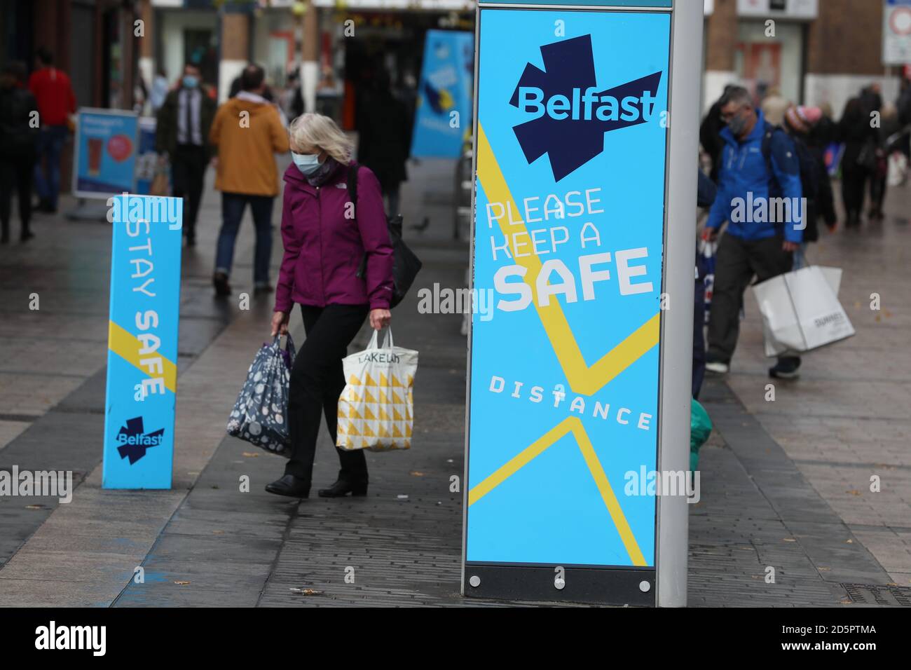 A woman wearing a face mask in belfast city centre hires stock