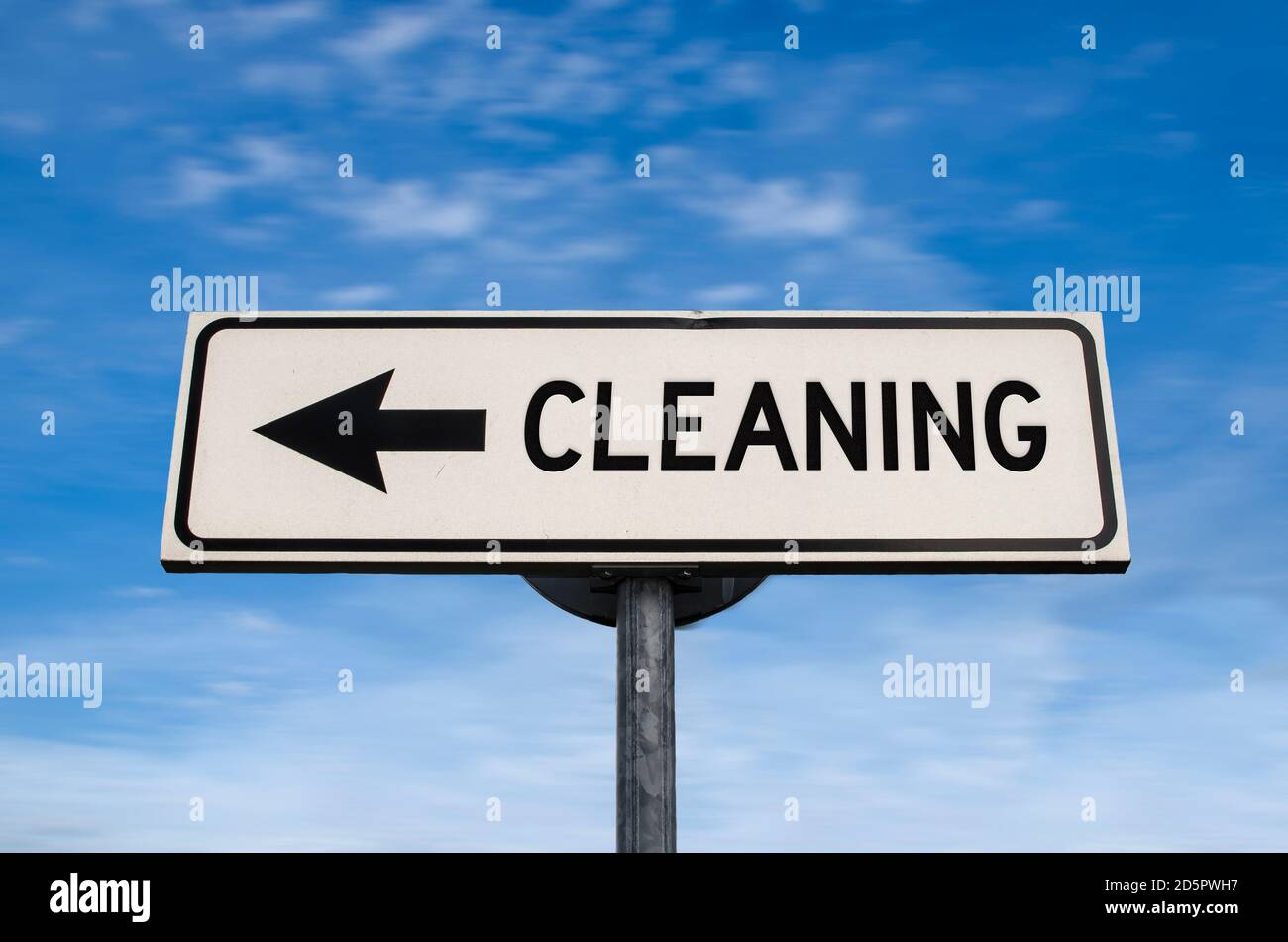 Cleaning road sign, arrow on blue sky background. One way blank road sign with copy space. Arrow on a pole pointing in one direction. Stock Photo