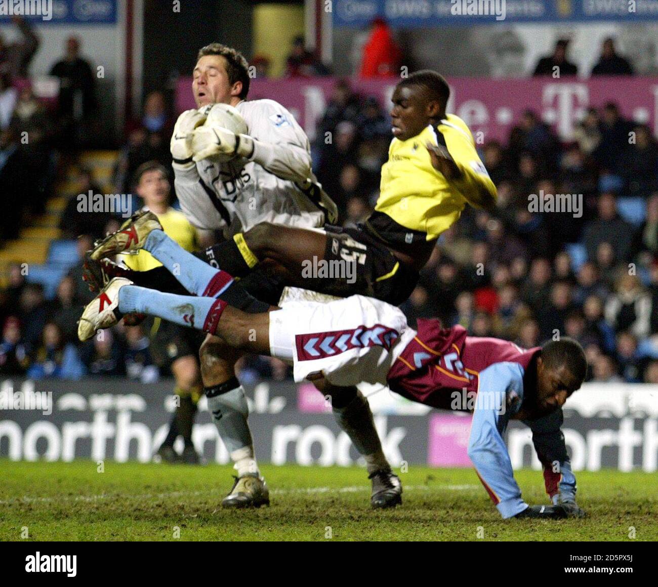 Aston Villa's goal keeper Thomas Sorensen collects the ball as Villa's Jlloyd Samuel and Manchester City's Micah Richards take a tumble. Stock Photo