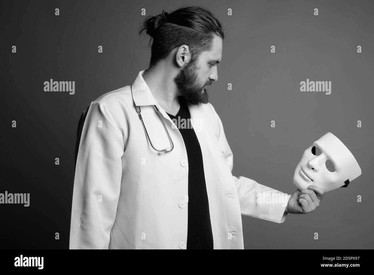 Young bearded man doctor against gray background Stock Photo