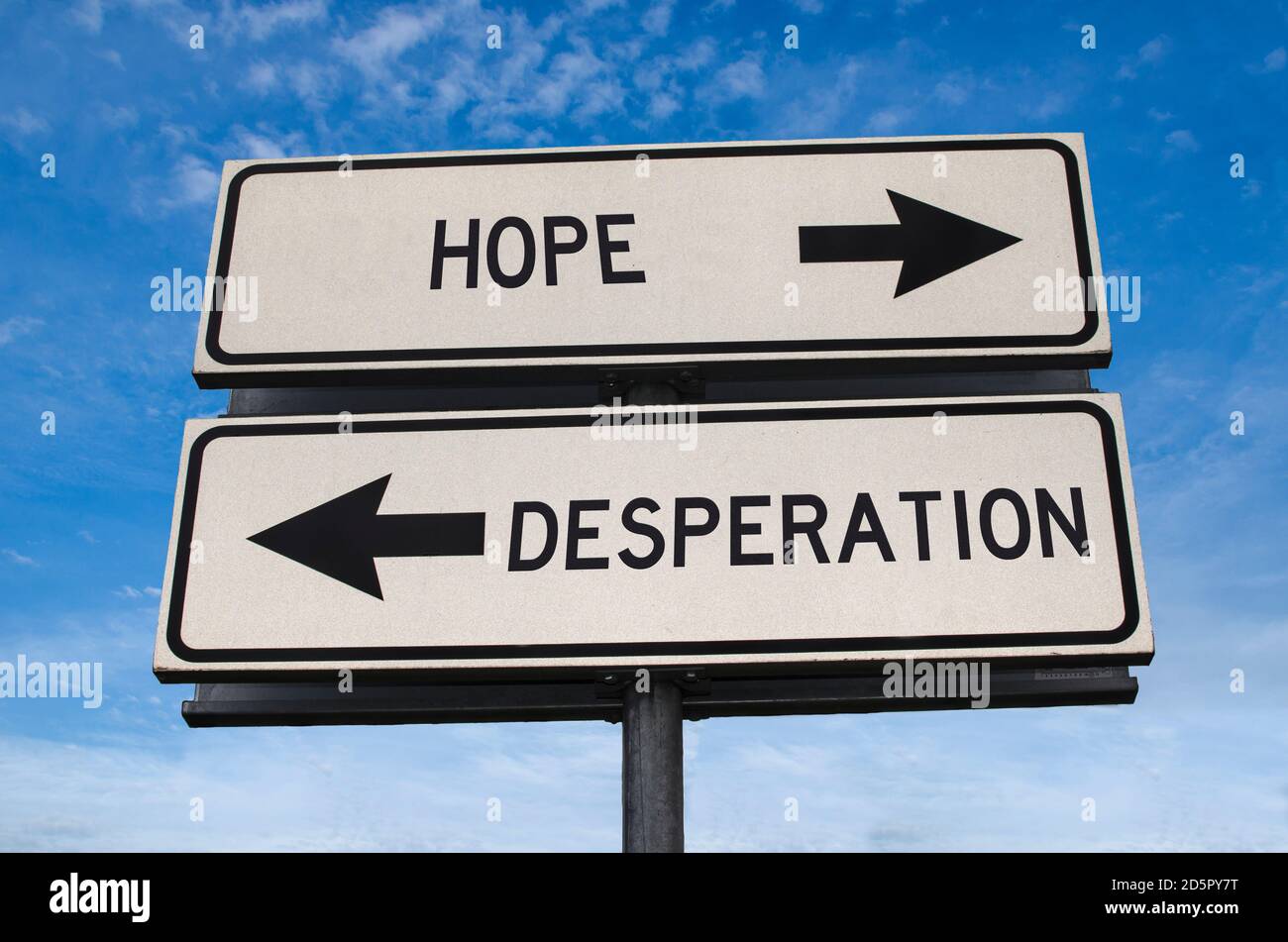 Hope vs desperation. White two street signs with arrow on metal pole with word. Directional road. Crossroads Road Sign, Two Arrow. Blue sky background Stock Photo