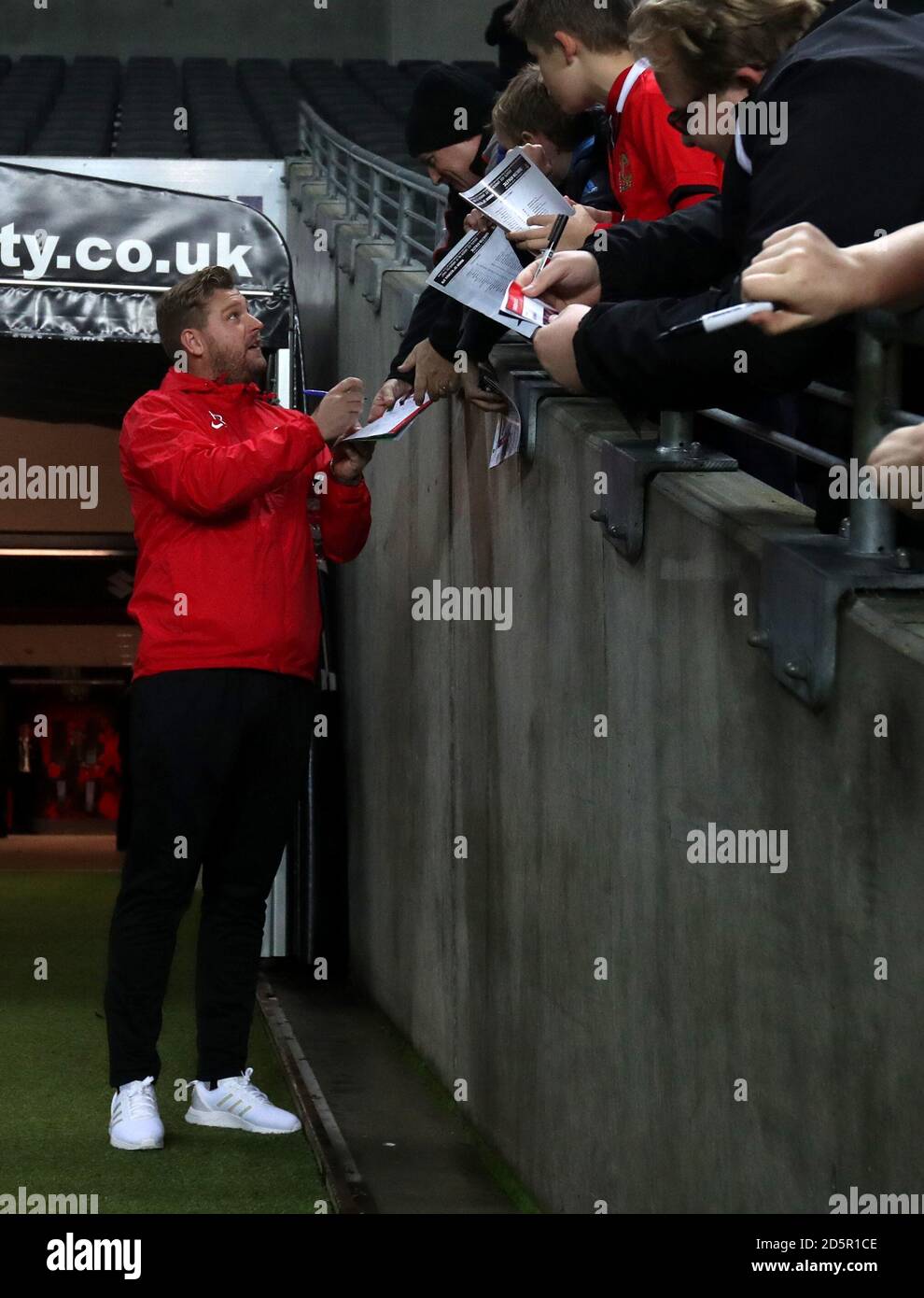 Charlton Athletic manager Karl Robinson signs autographs for the MK Dons fans prior to kick off Stock Photo