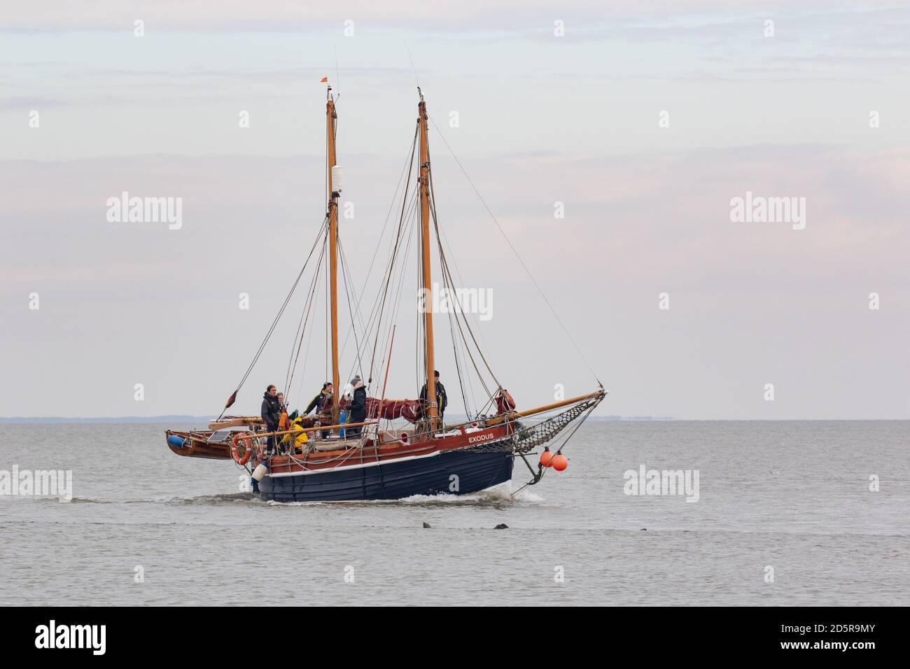 Old wooden yacht coming into port. Wadden Sea, Lower Saxony. Germany. October 20204 Stock Photo