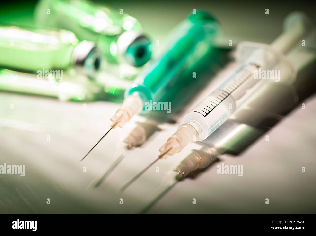 Two syringes and vials with vaccine in the spotlight Stock Photo - Alamy