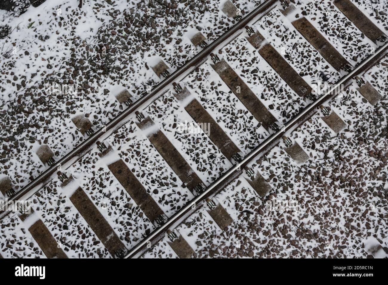 Overhead view of railway tracks with snow on ground Stock Photo