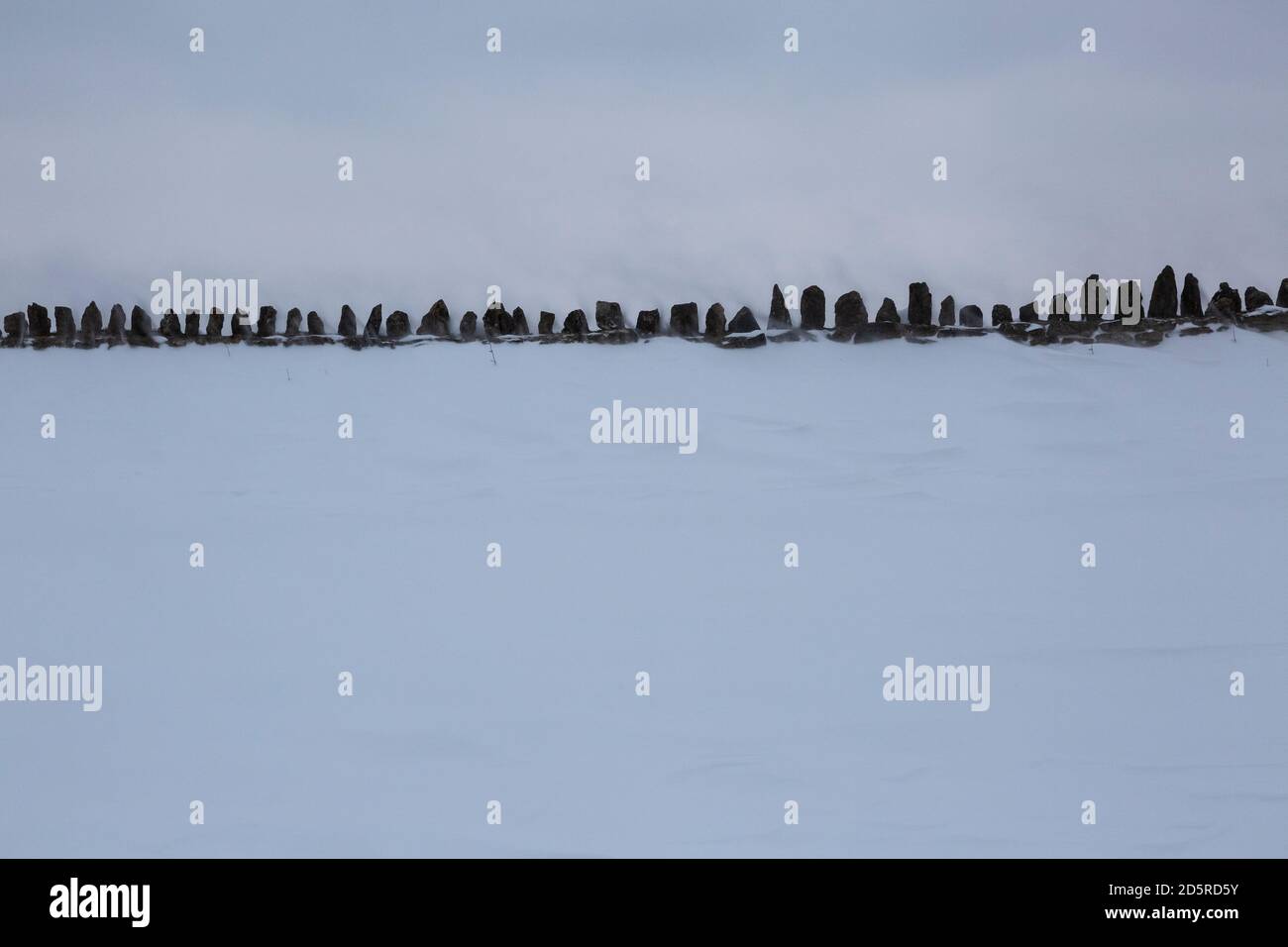Top of stone wall hidden by snow drift Stock Photo