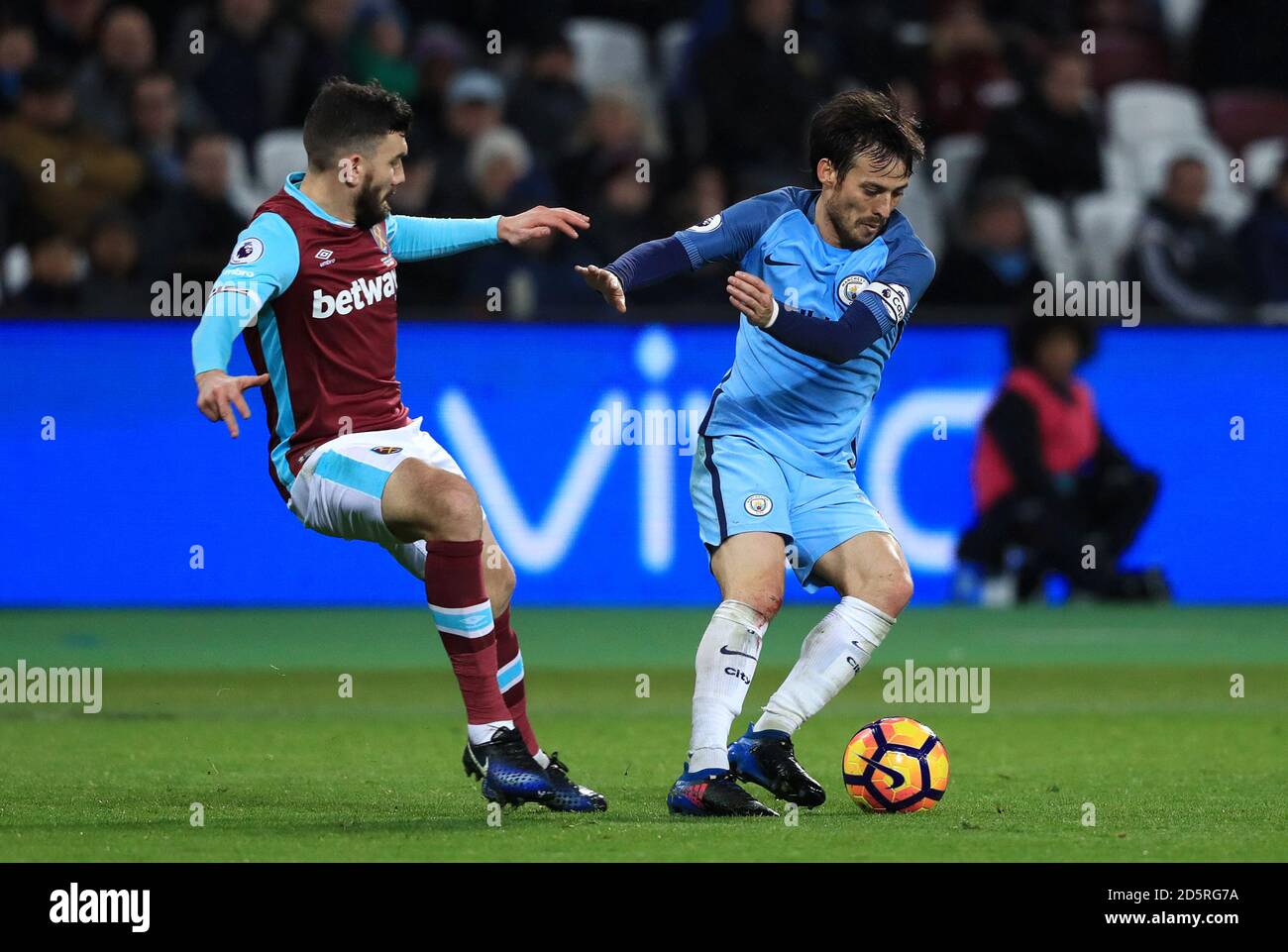 West Ham United's Robert Snodgrass (left) and Manchester City's David Silva battle for the ball Stock Photo