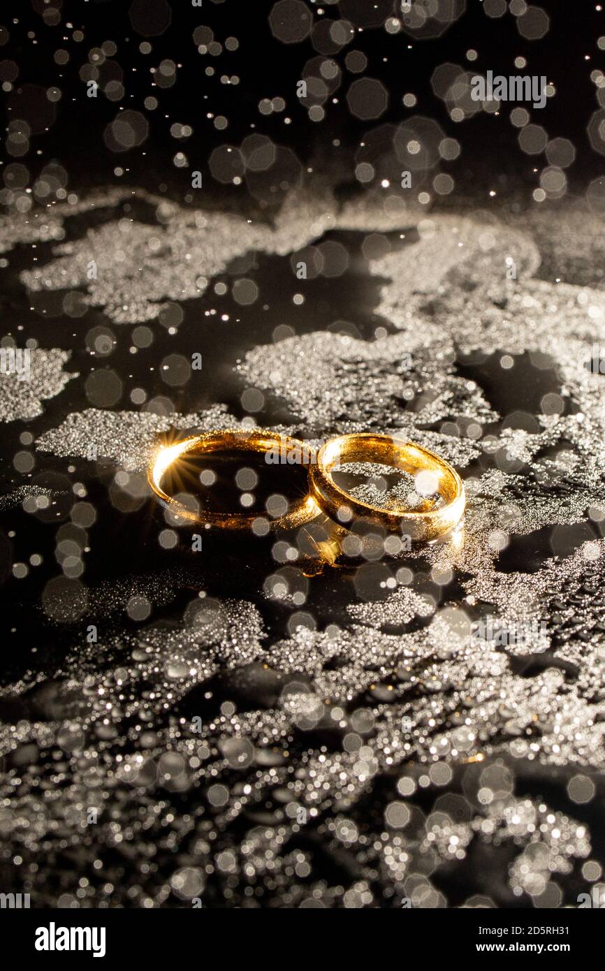 Two golden wedding rings on black background Stock Photo Alamy